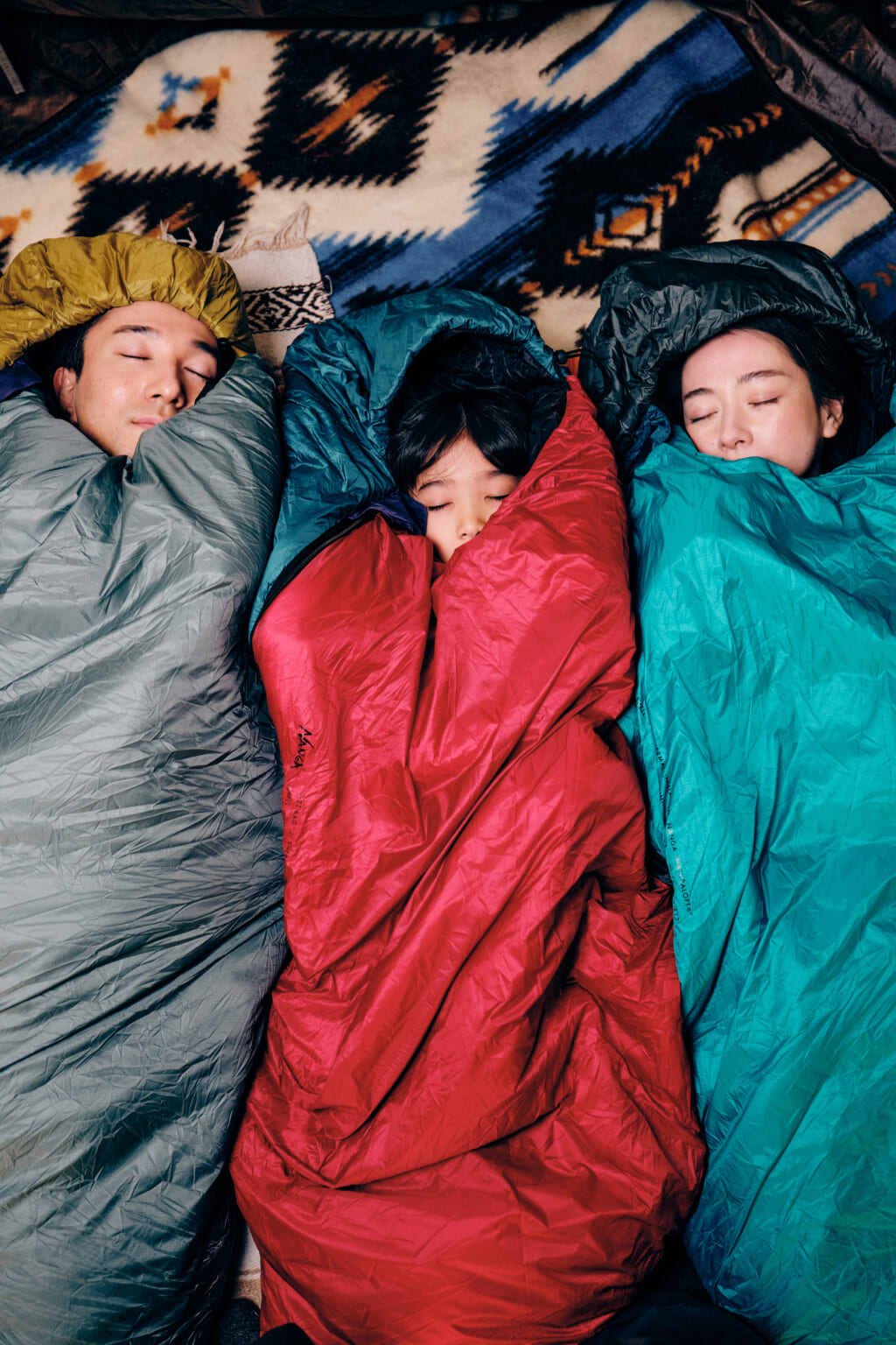 NANGA ZZZ BAG ファミリー3人が寝袋に入って横になっているキャンプシーン