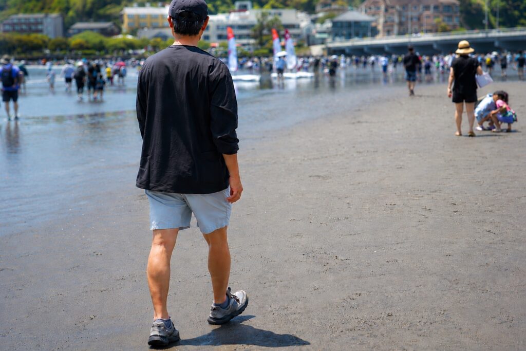 江ノ島トンボロをNANGA PLC EXCURSION L/S TOPSを着て散歩する様子