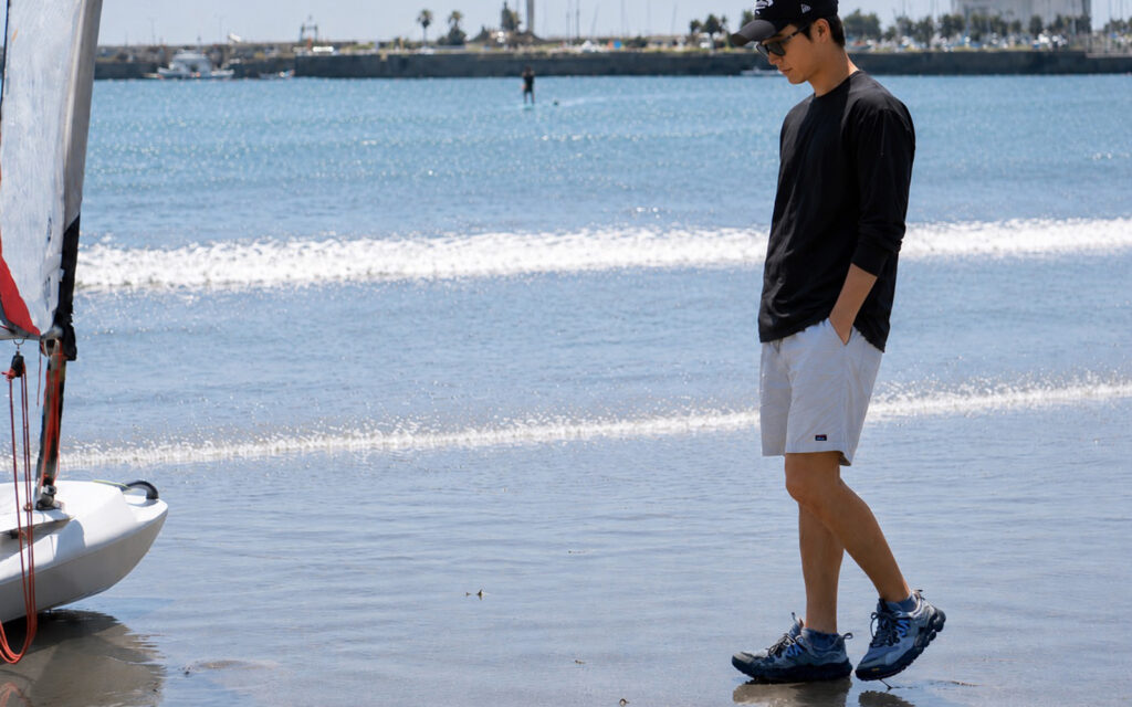 江ノ島トンボロでNANGA PLC EXCURSION L/S TOPSを着用している様子
