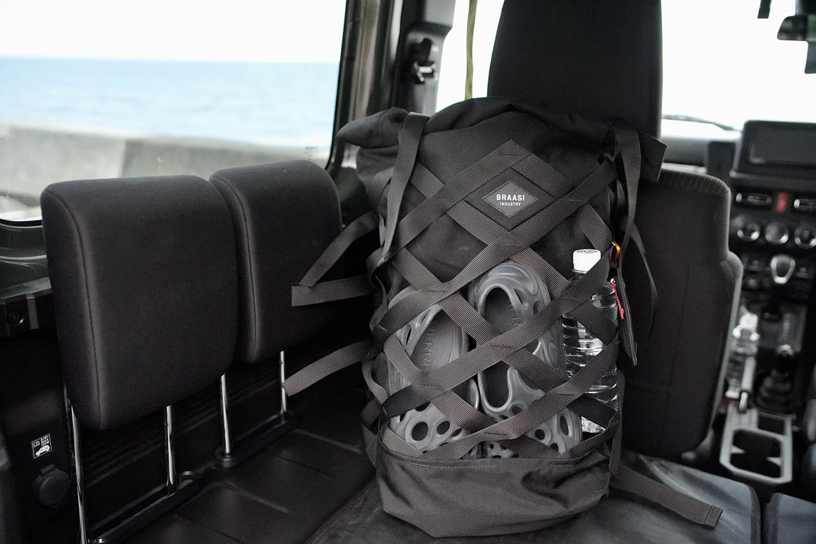 クロスネットにサンダルと水ボトルを収納して海へ向かうBRAASI Wicker 30L