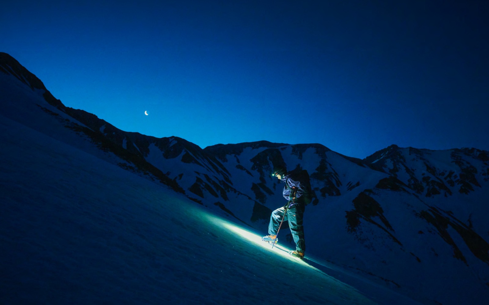 NANGA 2026年秋冬カタログのビジュアル（夜の雪山をヘッドライトで登る登山者）